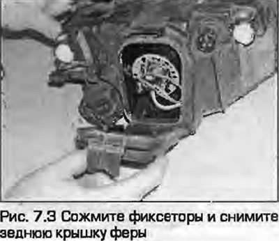 3. Сожмите фиксаторы и снимите заднюю крышку фары…