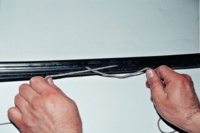 Перевернув стекло, заправляем в паз уплотнителя…