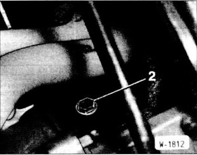 Подставить под двигатель чистый сосуд и отвернуть сливную пробку -2- на моторном блоке.
