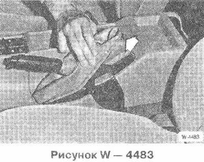 Поднять резиновый чехол рычага ручного тормоза…