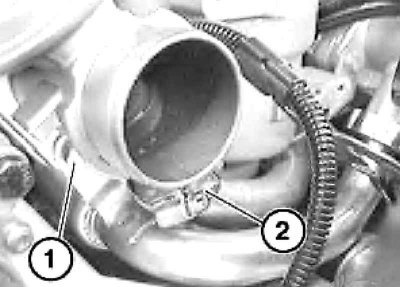 9. Выверните болты (1) и ослабьте хомуты (2)…
