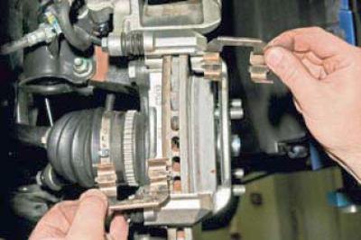 Снимаем две пружинные скобы колодок.