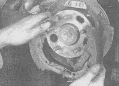 5.4л. Растянув колодки, чтобы освободить фланец…