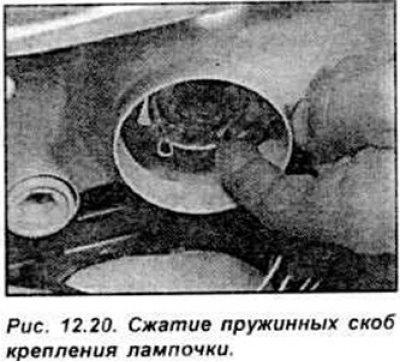 Сожмите пружинные скобы крепления лампочки и…