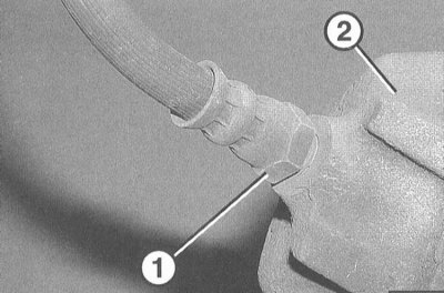 7. Выверните тормозной шланг (1) из суппорта (2).