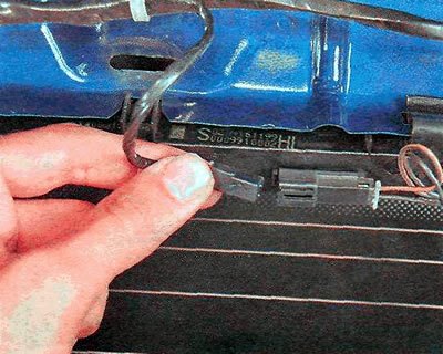 3. Отгибаем фиксатор и отсоединяем колодку жгута…