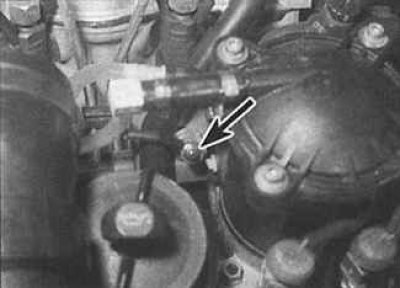 3. Отвинтите гайку крепления (указана стрелкой) токовой шины к свече накаливания. Обратите…