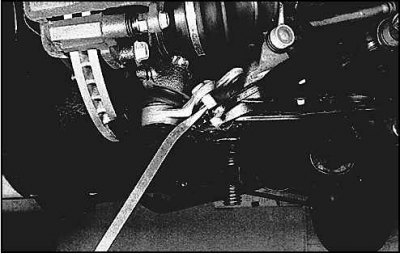 4. Действуя монтировкой, отведите рычаг подвески…