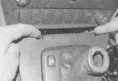 Рис. 28.11. Освободите две защелки впереди панели…